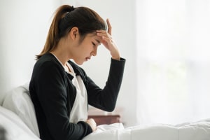 sick woman had headache hands touched her head bed